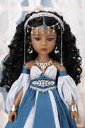 Doll in a blue and white dress with jewelry against a blurred background