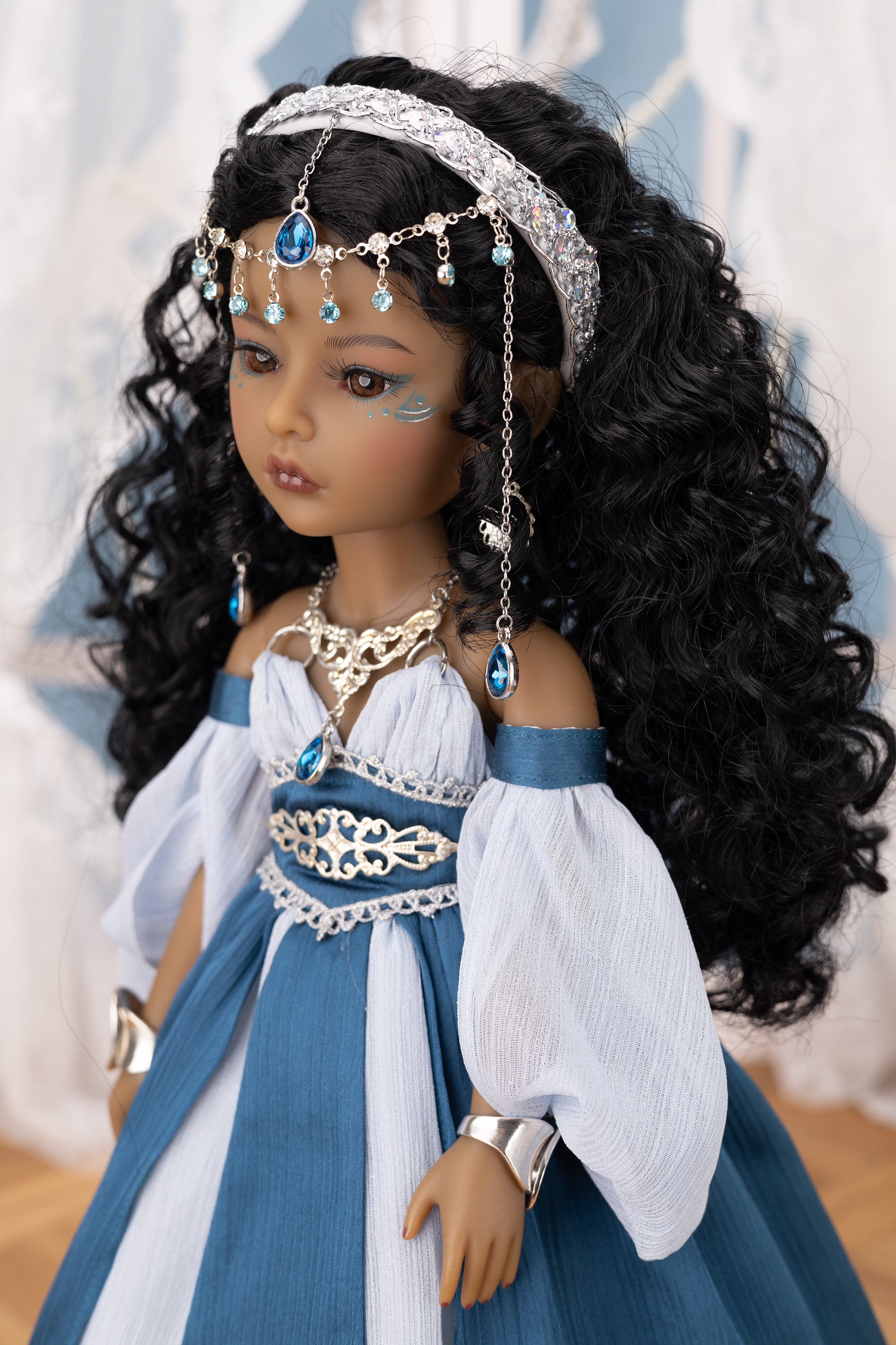 Doll with long black hair and traditional outfit with jewelry