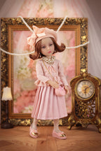 Lou in a pink outfit with a decorative background featuring a clock and framed picture.