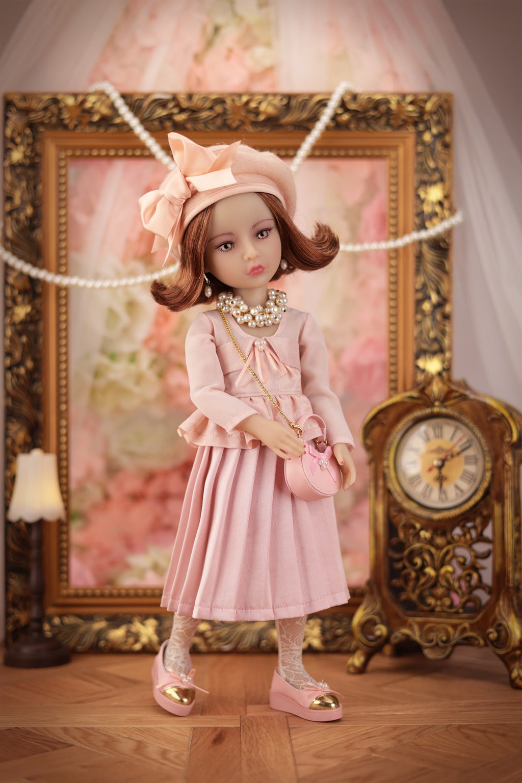 Lou in a pink outfit with a decorative background featuring a clock and framed picture.