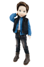 Doll wearing a blue jacket, black vest, jeans, and brown boots on a white background