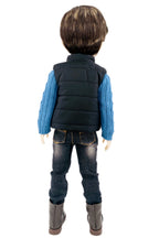 Back view of a doll wearing a black puffer vest, blue shirt, jeans, and brown boots on a white background.