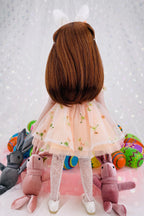 Back view of a doll with brown hair wearing a white dress surrounded by colorful plush toys on a light gray background.