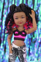 Doll with styled hair against a colorful, blurred background