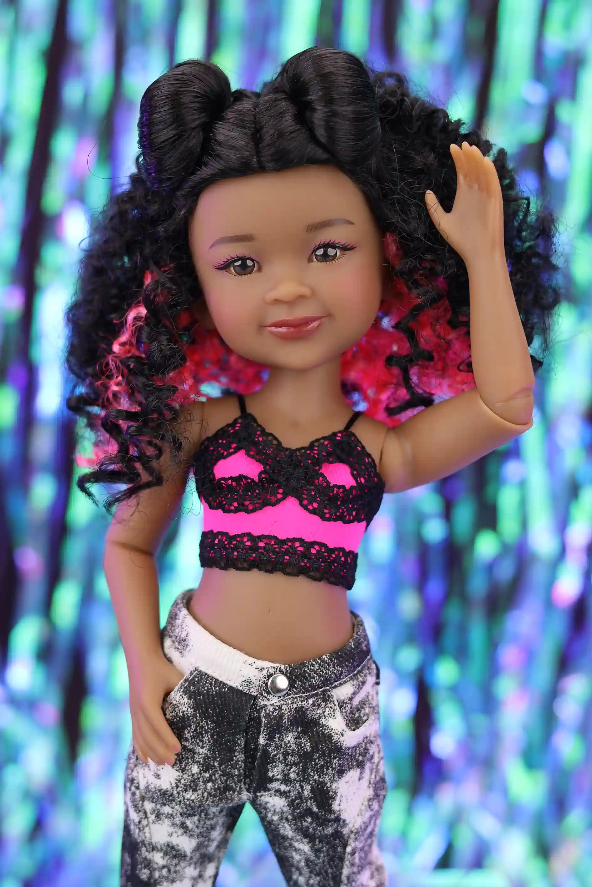 Doll with styled hair against a colorful, blurred background