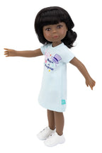 Doll wearing a light blue dress with colorful graphics on a white background