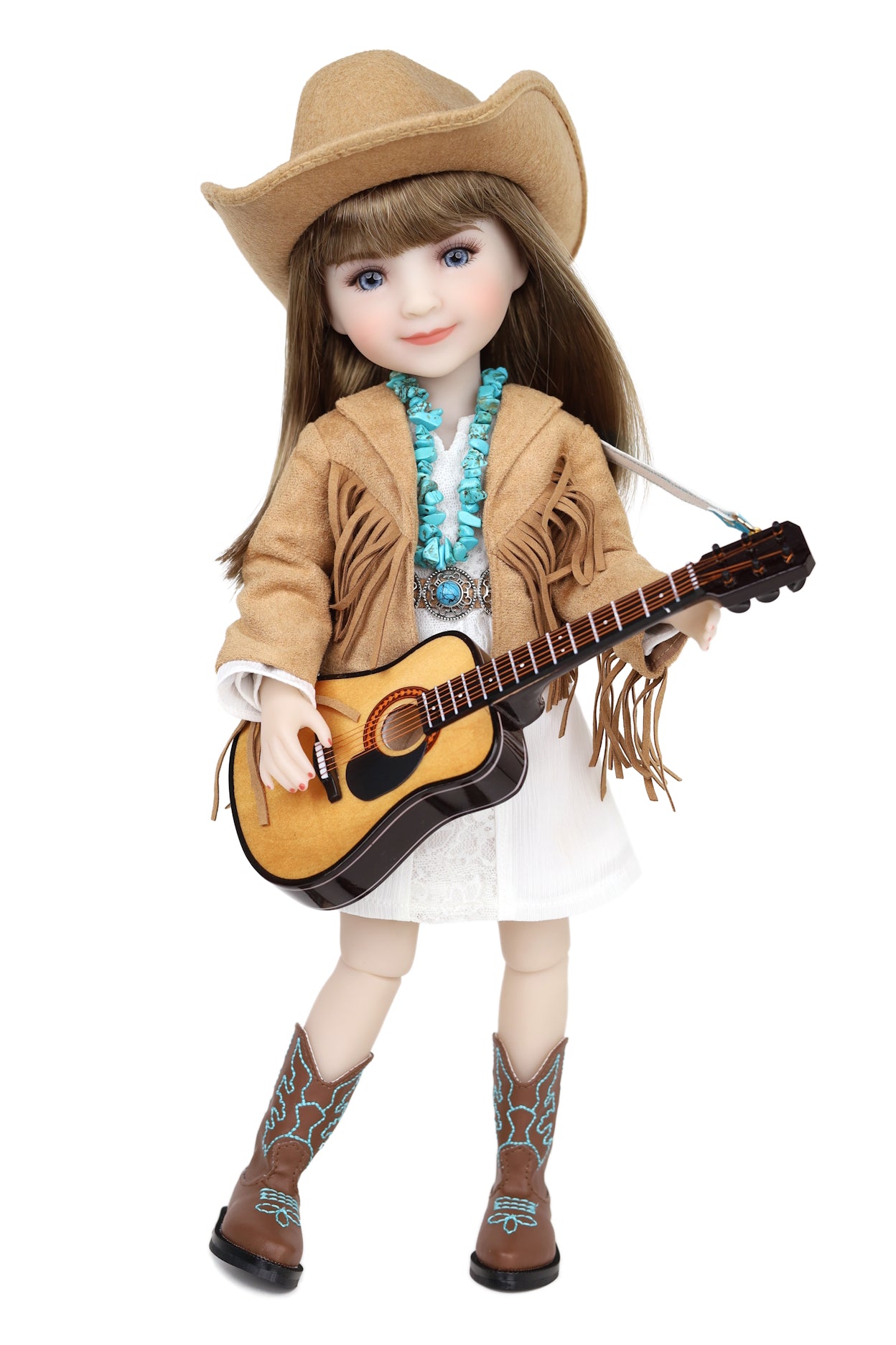 Doll in cowboy outfit with guitar on a white background
