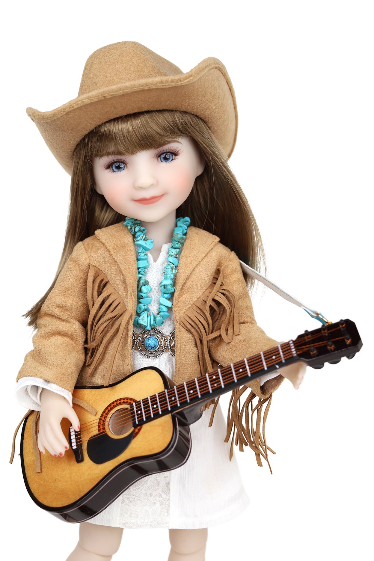 Doll dressed as a cowgirl holding a guitar on a white background