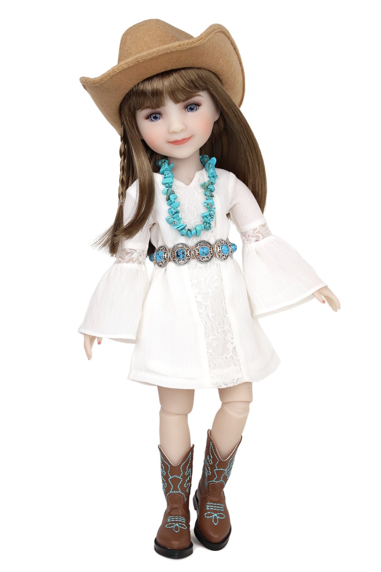 Doll wearing a white dress, brown cowboy hat, and boots with turquoise designs on a white background