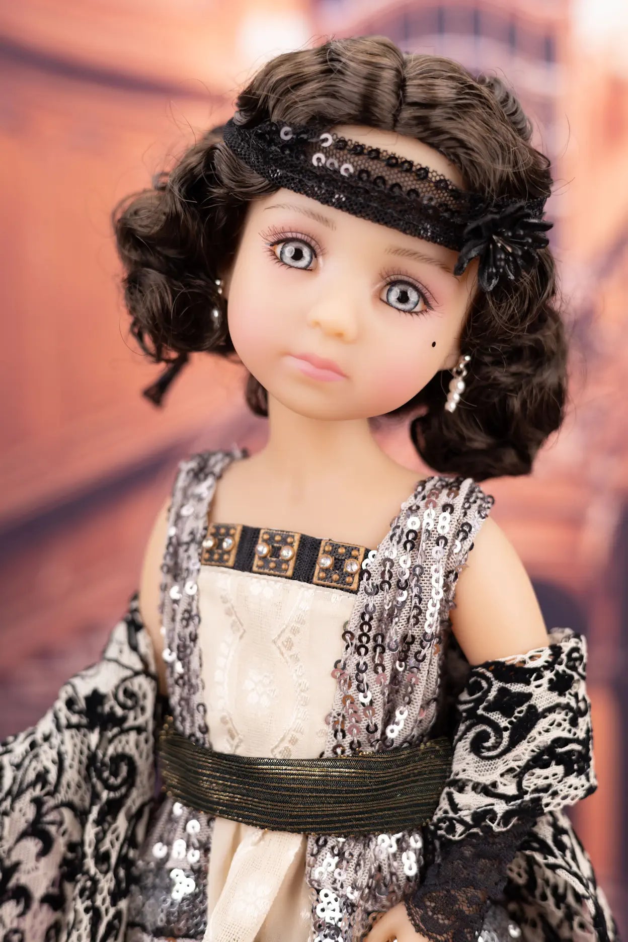 Doll with intricate clothing and jewelry against a blurred background