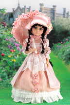 Doll in a pink historical dress with bonnet against a garden backdrop