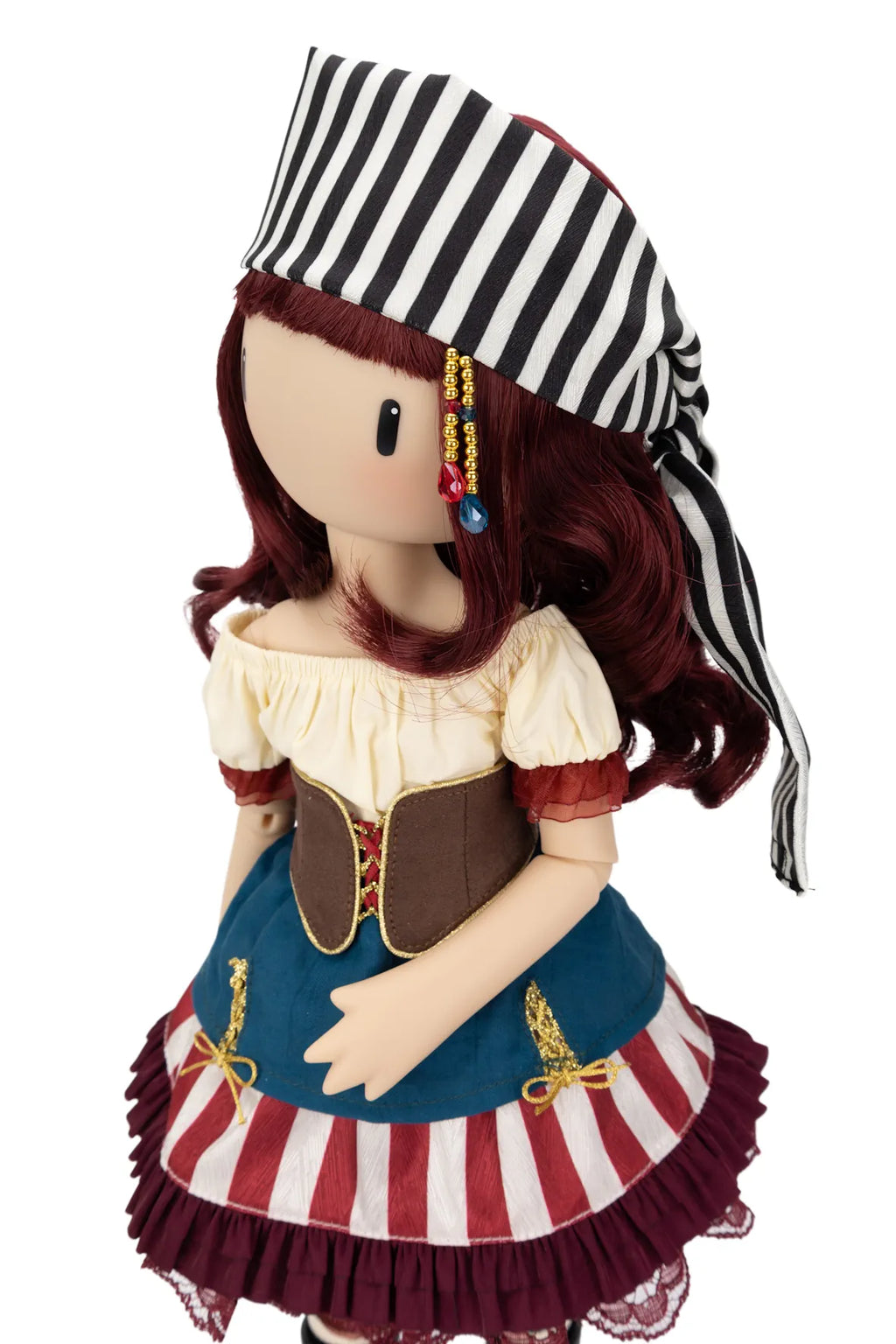 A pirate-themed Gorjuss doll with long burgundy hair, wearing a black and white striped hat, a cream puff-sleeve top, a brown corset, and a blue skirt with red and white stripes and dark ruffles, shown against a plain white background.