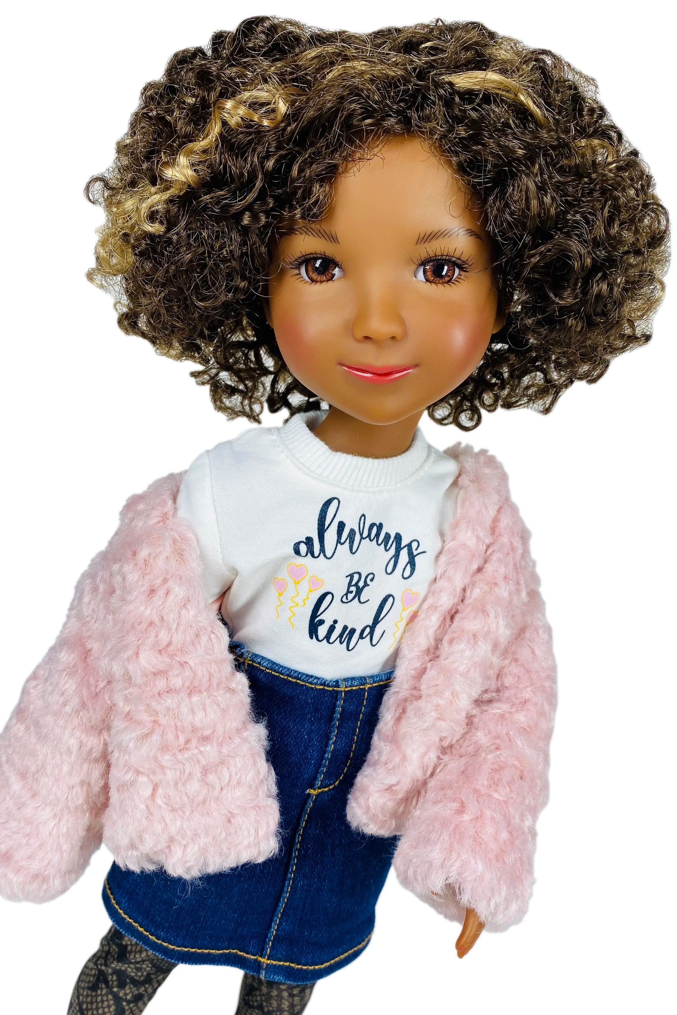 Doll wearing a pink jacket, white shirt with 'always be kind' text, and blue jeans on a white background