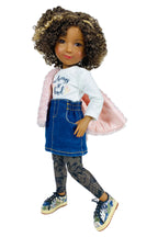 Doll wearing a white shirt with text, blue denim skirt, and patterned leggings on a white background