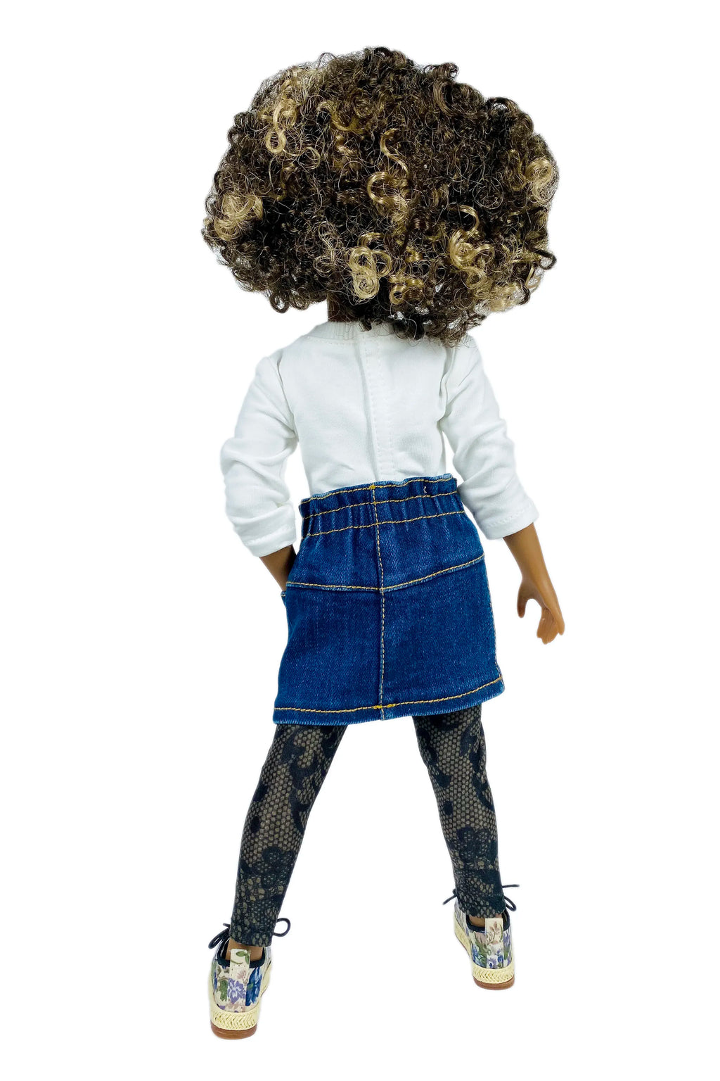 Doll wearing a white shirt, blue denim skirt, and patterned leggings on a white background