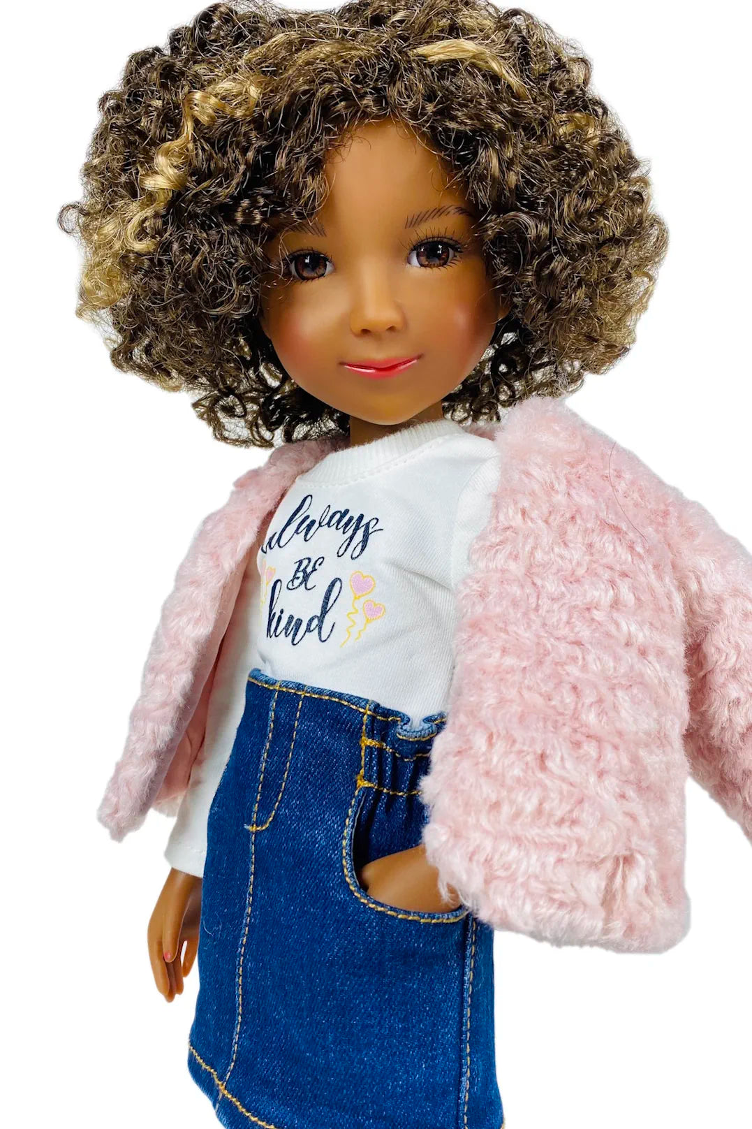 Maya doll wearing a pink jacket, white shirt with text, and blue denim skirt on a white background
