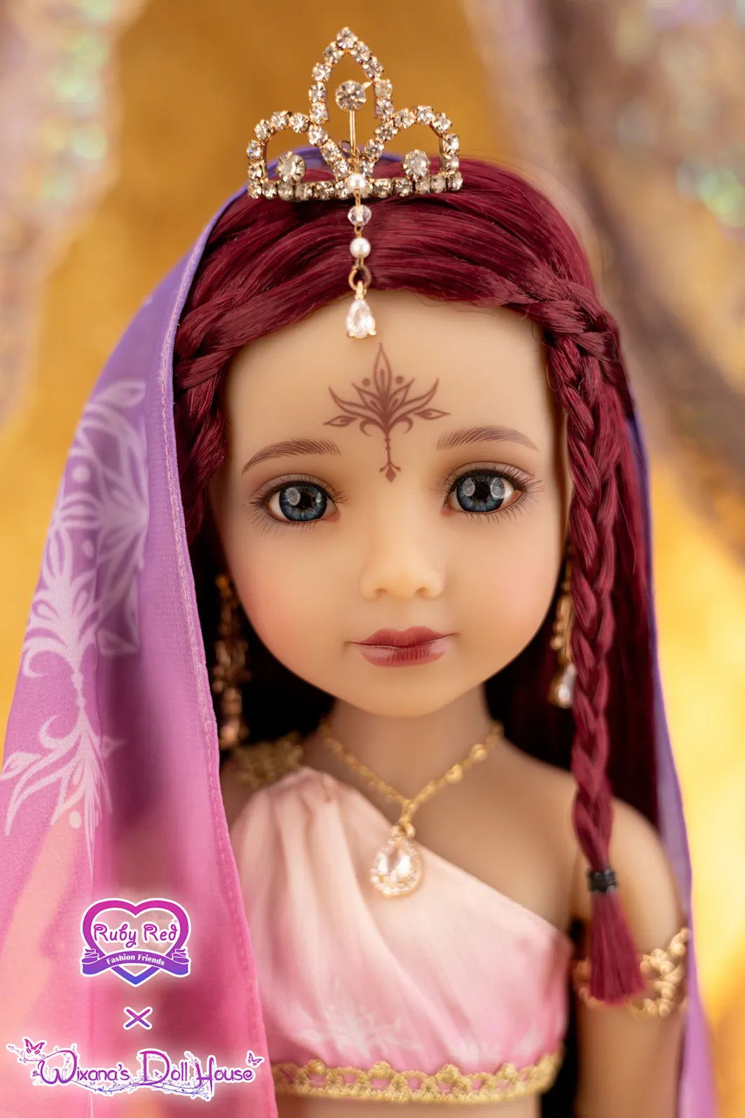 Doll with red hair, tiara, and pink headscarf on a blurred background