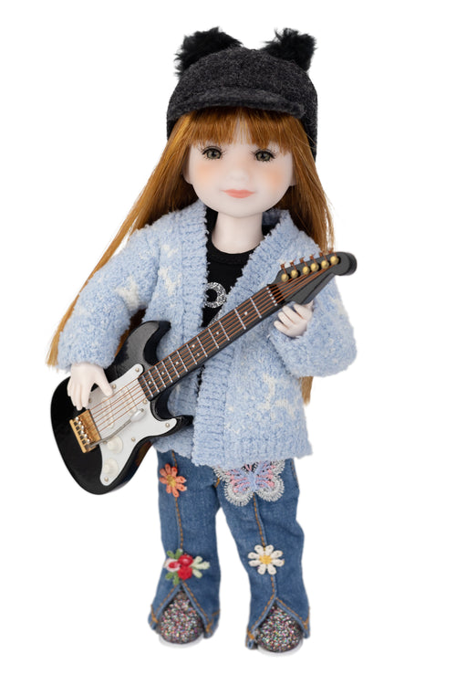 mini Stella wearing a blue cardigan, jeans, and a black hat holding a guitar on a white background
