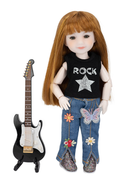 mini Stella doll with red hair wearing a 'Rock' shirt and jeans next to a guitar on a white background