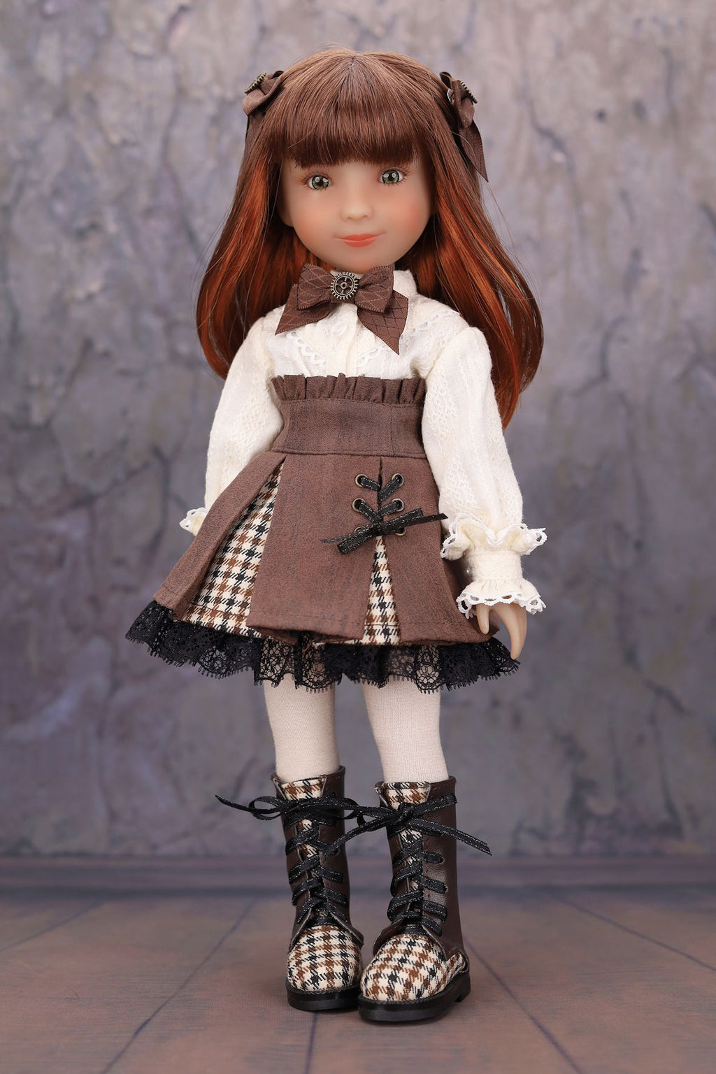 Doll with brown hair and outfit standing against a textured gray background