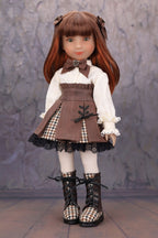Doll with brown hair and outfit standing against a textured gray background