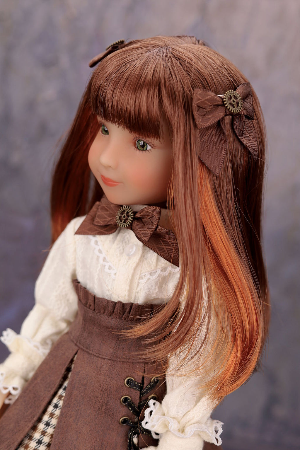 Doll with long brown hair and vintage-style clothing against a neutral background
