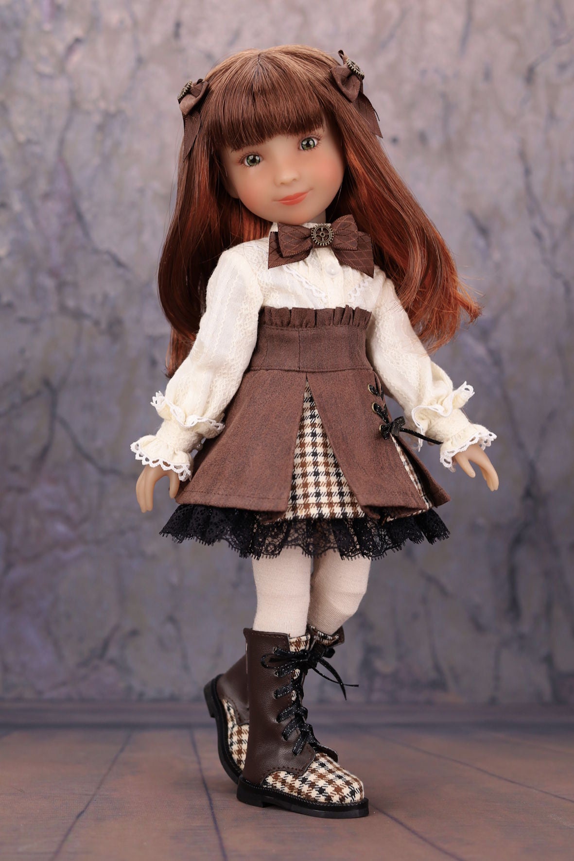 Doll with brown hair and outfit against a textured gray background