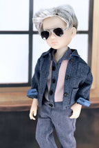 Doll wearing a blue outfit with sunglasses against a neutral background