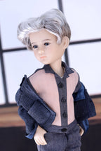 Doll with gray hair wearing a dark blue outfit against a neutral background