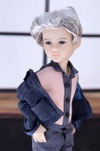 Doll with gray hair and gray outfit against a blurred background