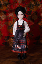 Doll wearing a detailed dress with a floral background