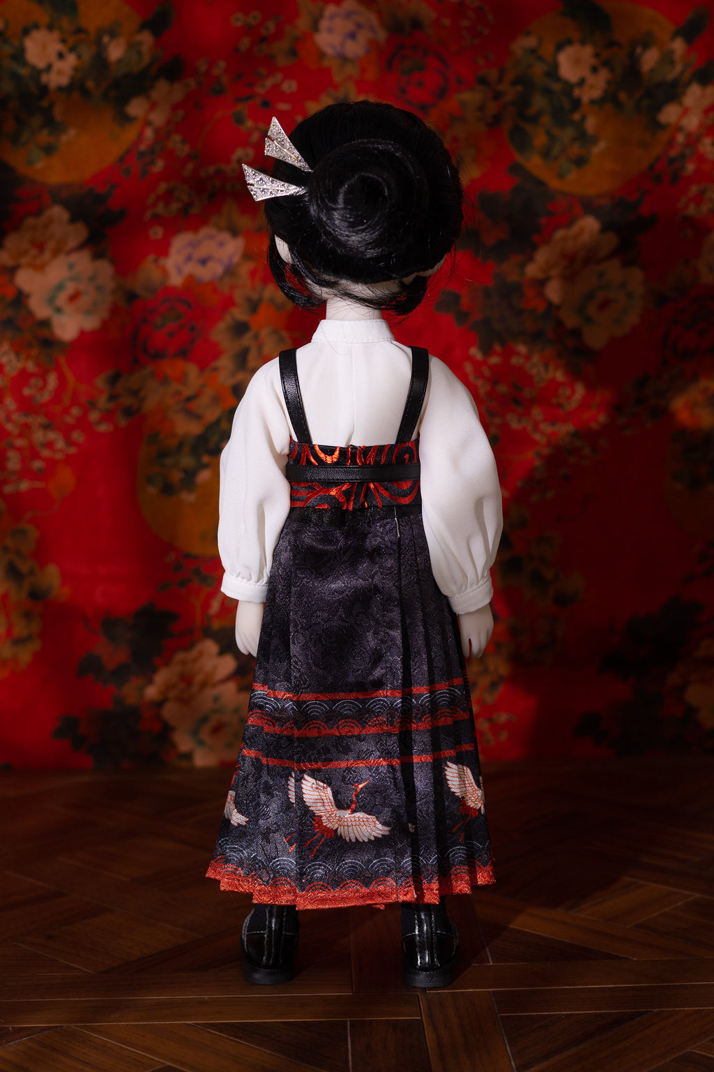 Doll wearing a traditional outfit with a floral background