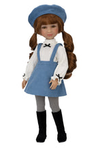 Doll wearing a blue dress with pinafore, white shirt, and black boots on a white background
