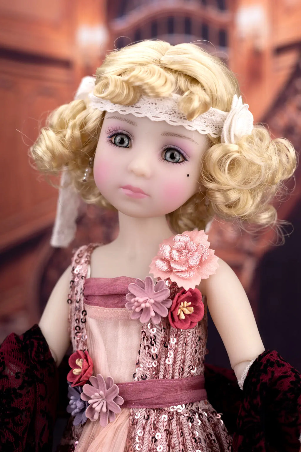 Detailed doll with blonde hair, floral headband, and decorative outfit against a blurred background