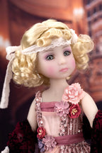 Detailed doll with blonde hair, floral dress, and decorative headband against a blurred background
