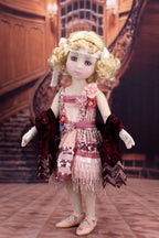 Doll in a vintage outfit with a decorative background
