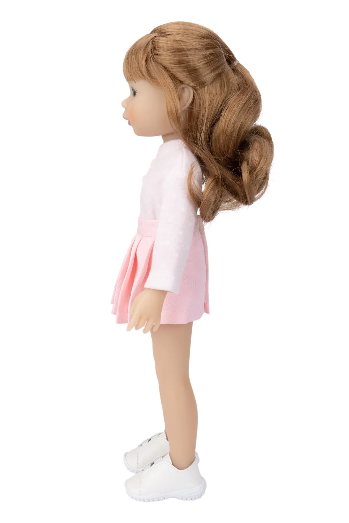 Doll with long brown hair wearing a white top and pink skirt on a white background