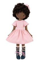 Doll with pink dress and curly hair on a white background