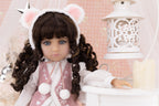 Doll with bear ears and pink outfit in a decorative setting