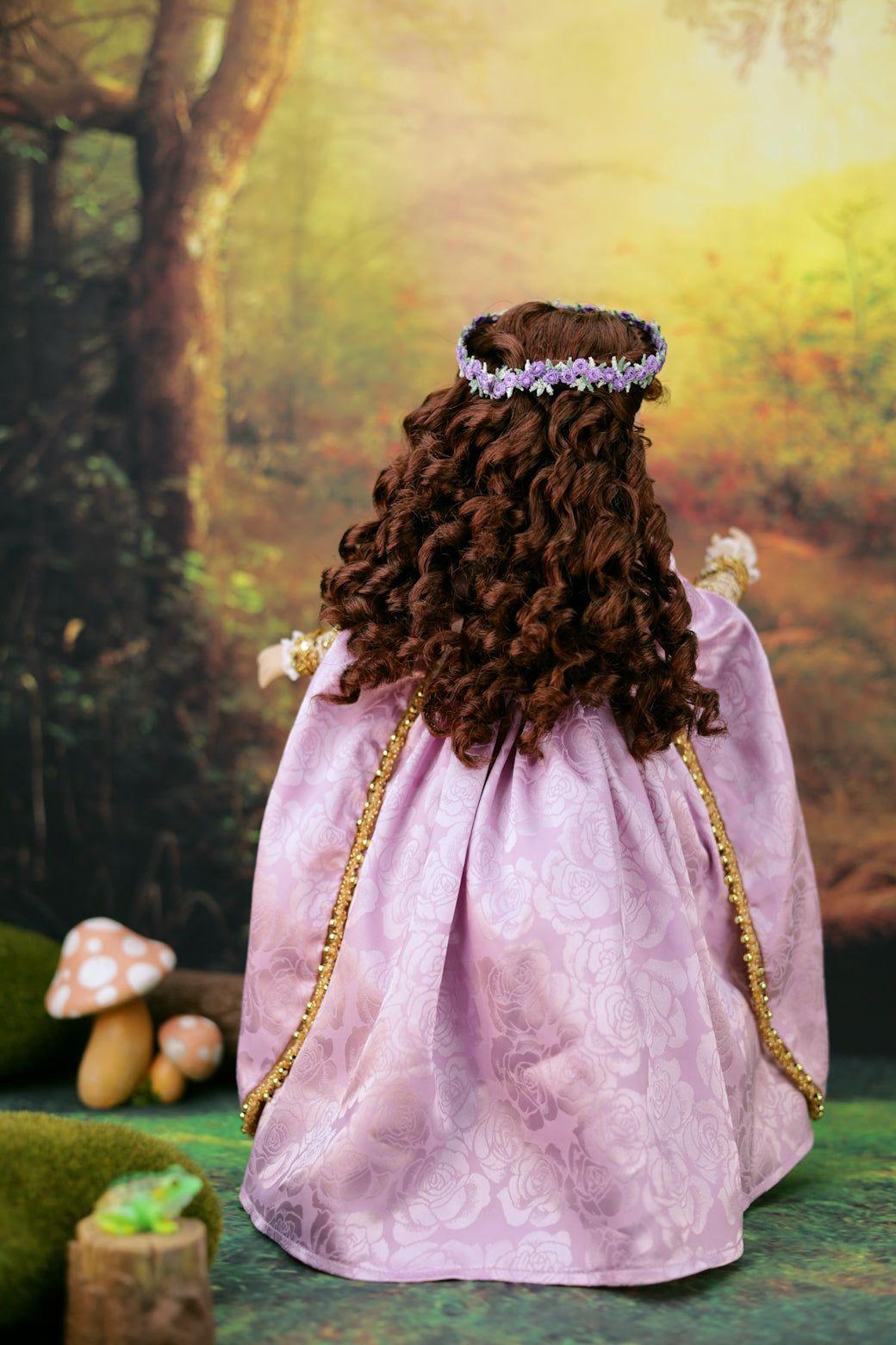 Princess Zora doll with a purple dress and flower crown, standing in a forest setting.