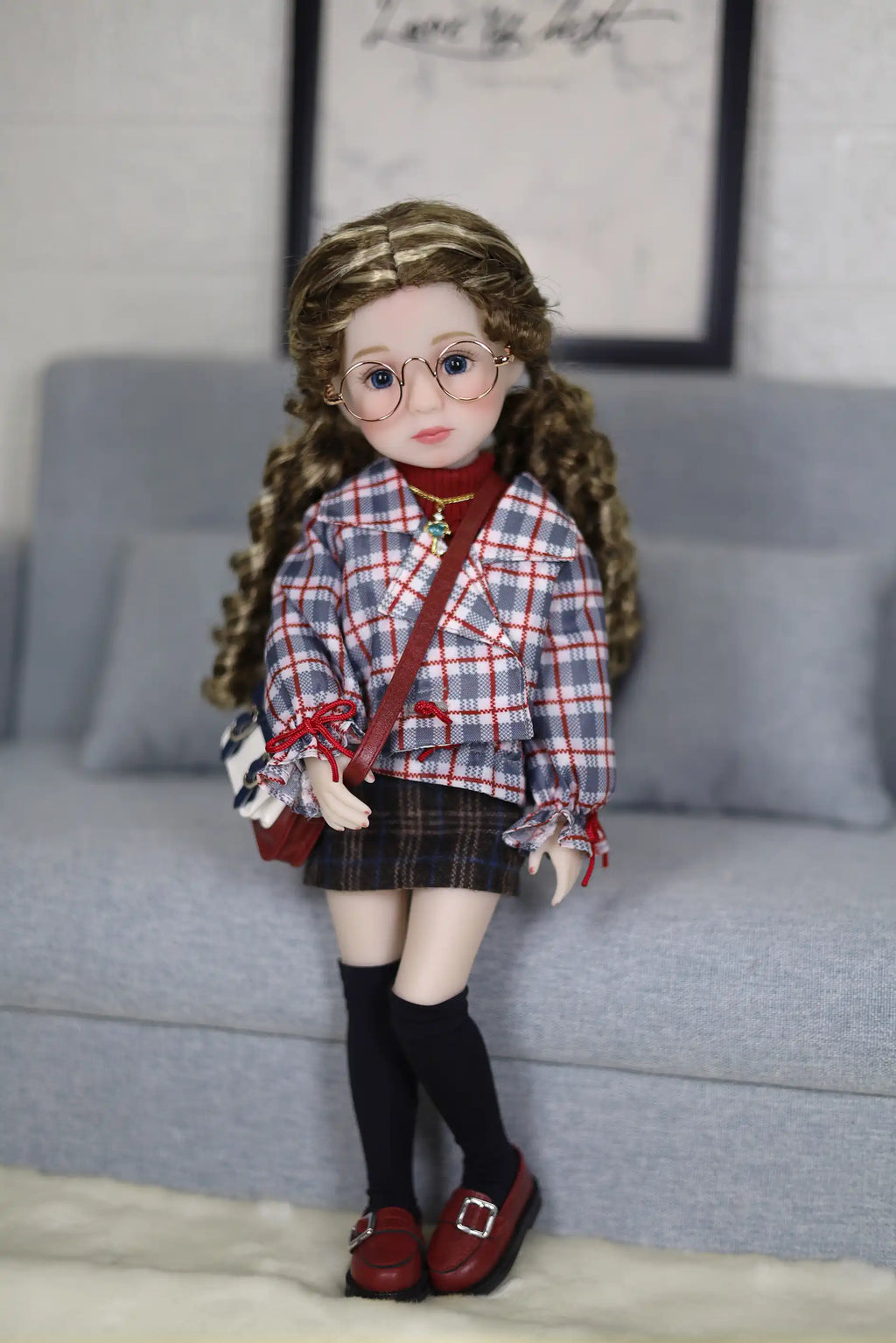 Doll with plaid shirt and skirt standing on a couch