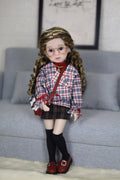 Doll with plaid shirt and skirt standing on a couch