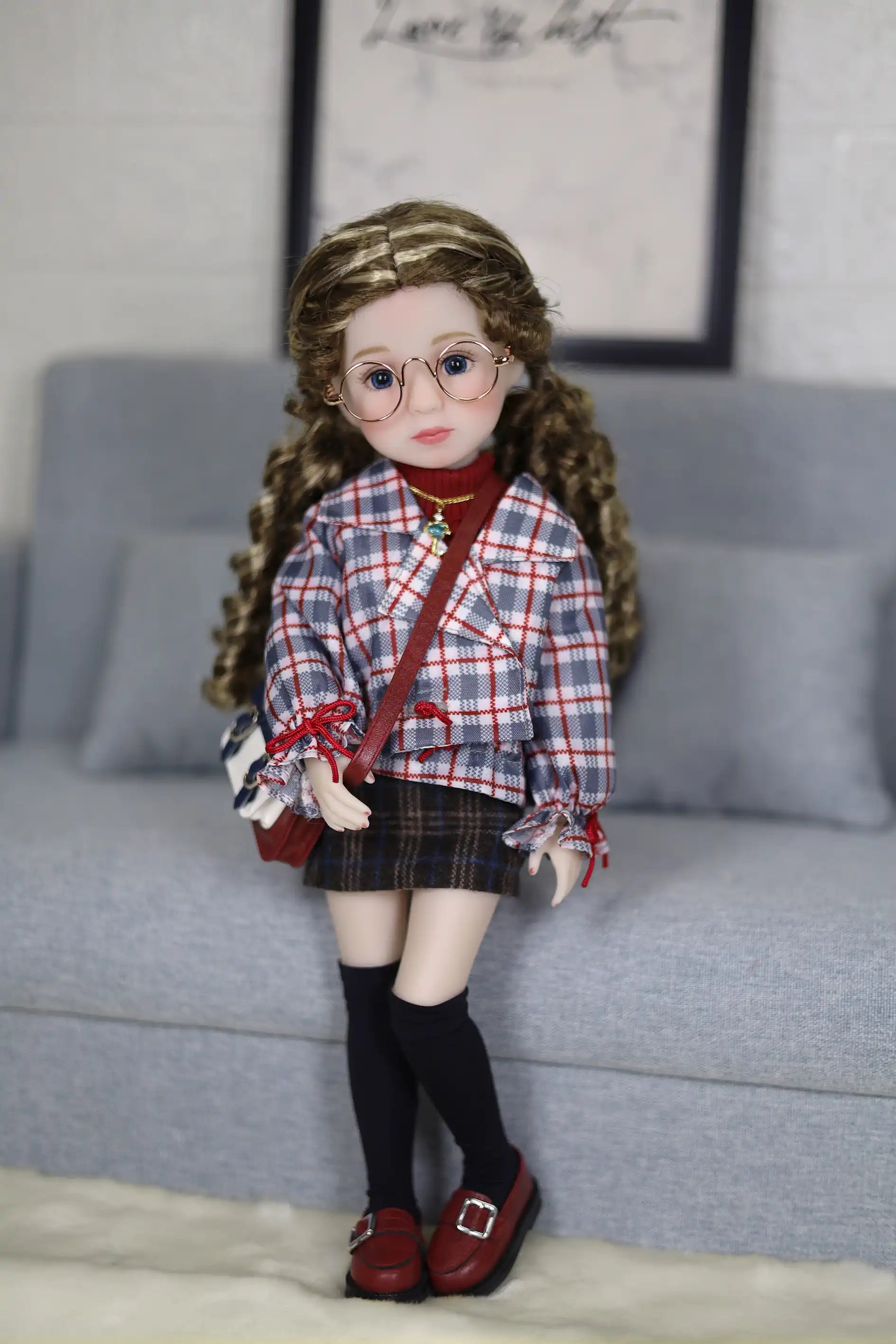 Doll with plaid shirt and skirt standing on a couch