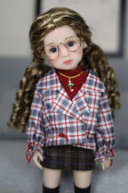 Doll wearing a plaid shirt and skirt with a red sweater underneath, on a neutral background.