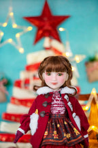 Doll in a festive outfit with a Christmas tree and star decoration in the background.