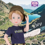 Doll named Rory wearing a cap and 'Wild Man' t-shirt with a mountainous landscape background.