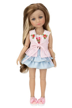 Doll wearing a pink top with floral embroidery and a blue skirt on a white background