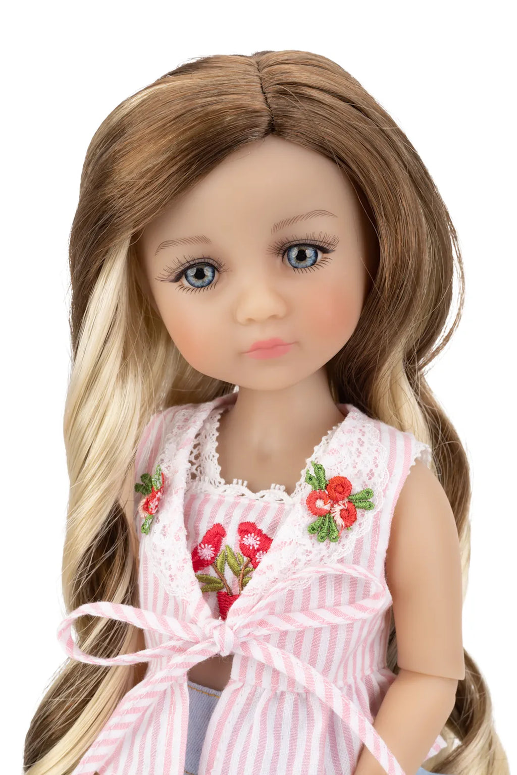 Doll with long brown and blonde hair wearing a pink dress with floral details on a white background