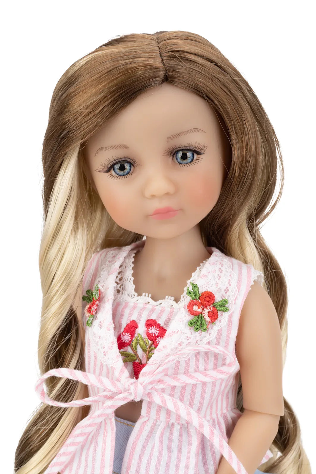Doll with long brown and blonde hair wearing a pink dress with floral details on a white background