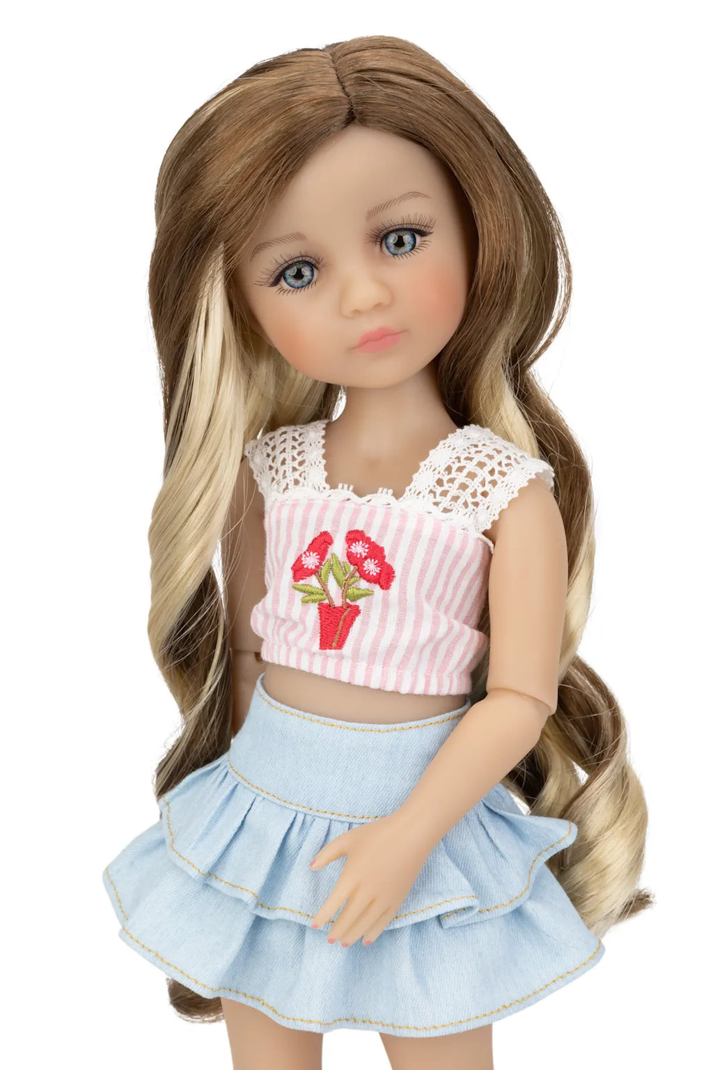 Doll with long brown hair wearing a pink top and blue skirt on a white background